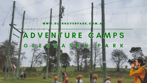 Glenhaven Park Camps Children in safety helmets participating in a ropes course at glenhaven park adventure camps, with an instructor watching through binoculars.